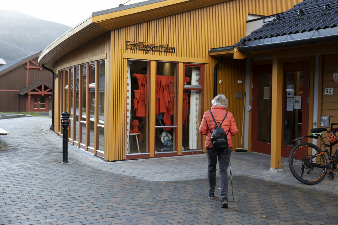 Kvinne går inn i gult hus.