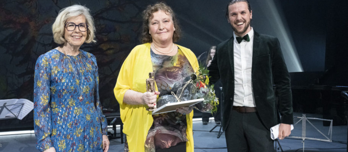 Kvinne får blomst av kvinne og mann.